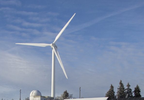 a windmill above solar panels